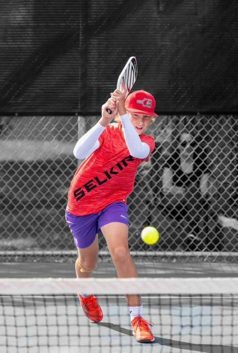 Hands holding a pickleball
