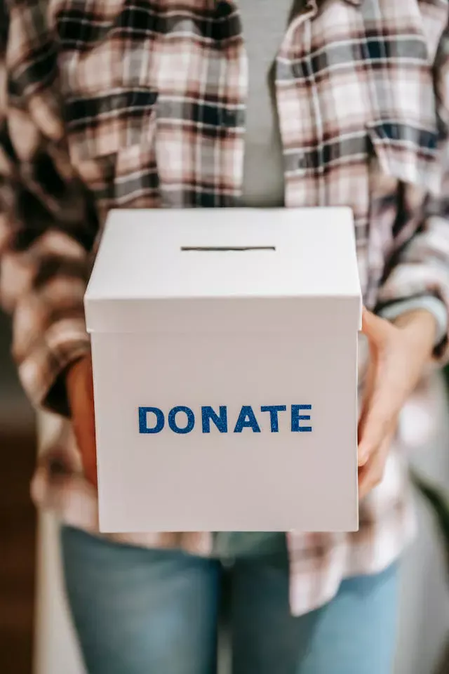 woman holding a white box with the works donate in blue